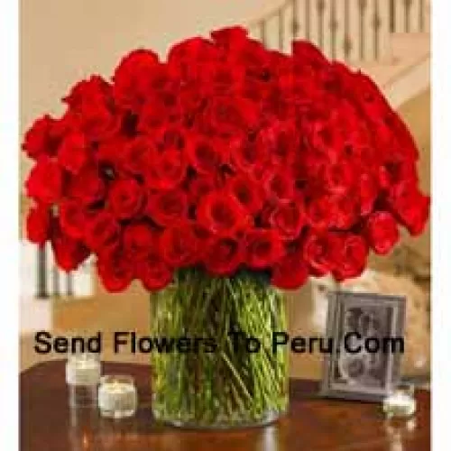 100 Red Roses With Some Ferns In A Big Glass Vase